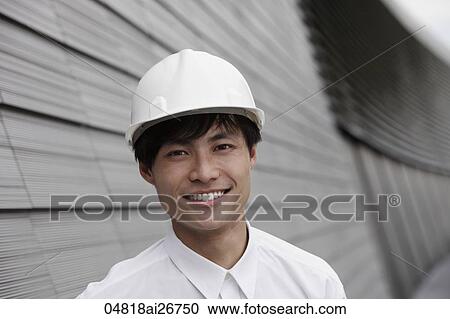 man wearing construction hat smiling in front of building View Large Photo Image Stock Image - man wearing construction hat smiling in front of building. Fotosearch