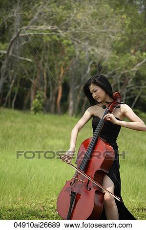 Woman playing cello surrounded by nature View Large Photo Image Stock Photo - Woman playing cello surrounded by nature. Fotosearch