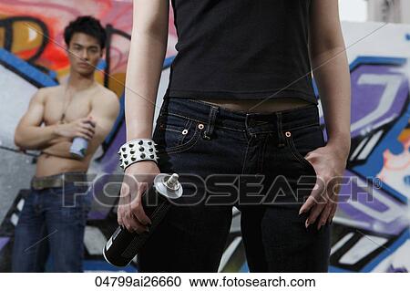 Young couple posing with spray cans in front of graffiti wall. View Large Photo Image Stock Image - Young couple posing with spray cans in front of graffiti wall.. Fotosearch