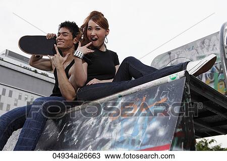 Young couple sitting on graffiti wall. View Large Photo Image Stock Image - Young couple sitting on graffiti wall.. Fotosearch