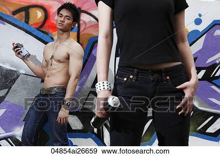 Young couple spray painting graffiti wall together View Large Photo Image Stock Photo - Young couple spray painting graffiti wall together. Fotosearch