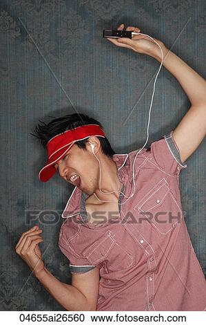 Young man singing while listening to MP3 player View Large Photo Image Stock Image - Young man singing while listening to MP3 player. Fotosearch