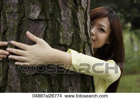 Picture - Young woman hugging tree. Fotosearch