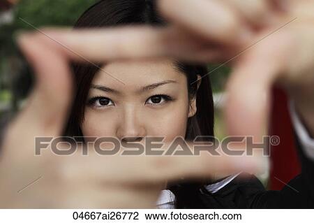 Young woman looking through fingers making a frame View Large Photo Image Stock Image - Young woman looking through fingers making a frame. Fotosearch