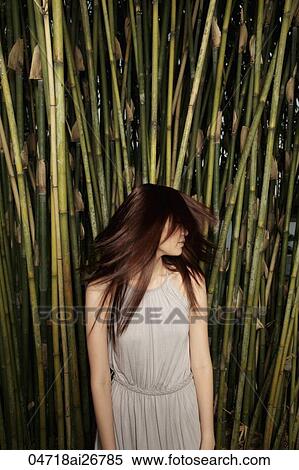 Young woman shaking her hair in front of bamboo View Large Photo Image Stock Photography - Young woman shaking her hair in front of bamboo. Fotosearch