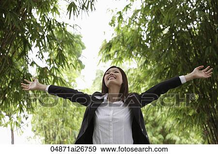 Young woman wearing a suit and raising her arms up outside View Large Photo Image Stock Photo - Young woman wearing a suit and raising her arms up outside. Fotosearch