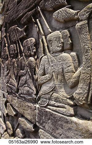 Stock Image - carved stone images on the all of Angkor Wat, Combodia. Fotosearch