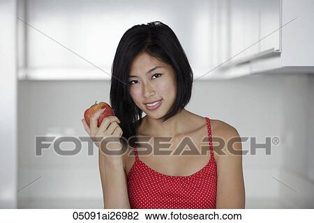 head shot of young woman holding red apple and smiling View Large Photo Image Stock Image - head shot of young woman holding red apple and smiling. Fotosearch
