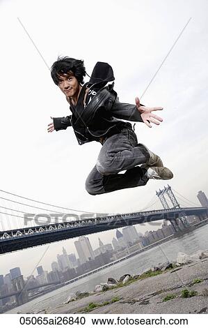 Man jumping high in the air in front of a bridge View Large Photo Image Stock Image - Man jumping high in the air in front of a bridge. Fotosearch