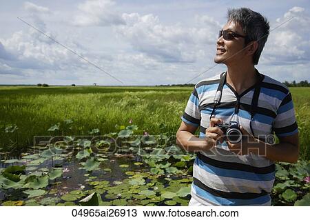 man outside holding camera and smiling View Large Photo Image Stock Image - man outside holding camera and smiling. Fotosearch