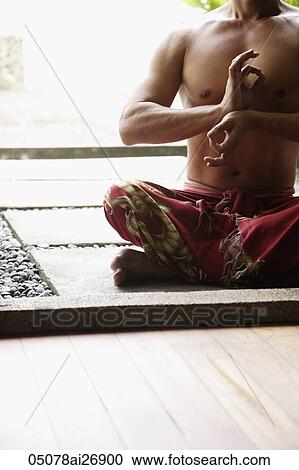 man sitting cross legged and holding fingers in meditative pose View Large Photo Image Stock Image - man sitting cross legged and holding fingers in meditative pose. Fotosearch