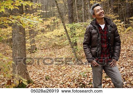 man walking through forest with leaves changing colours View Large Photo Image Stock Photo - man walking through forest with leaves changing colours. Fotosearch