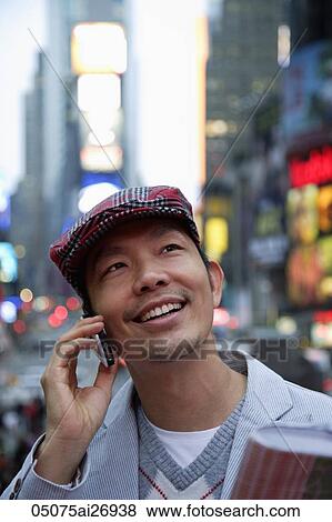 man wearing hat talking on phone in the evening, city lights as background View Large Photo Image Stock Photo - man wearing hat talking on phone in the evening, city lights as background. Fotosearch