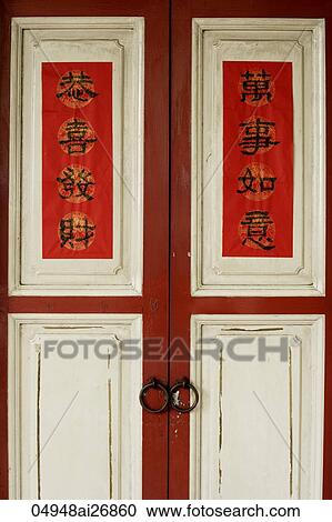 Stock Image - Old wooden doors with Happy New Year written in Chinese characters.. Fotosearch