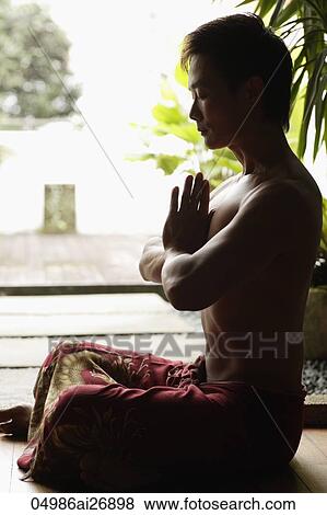 Profile of man sitting crossed legged and meditating View Large Photo Image Stock Photo - Profile of man sitting crossed legged and meditating. Fotosearch