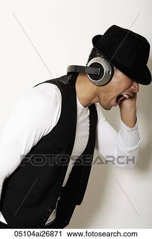 profile of young man wearing a hat with earphones yelling View Large Photo Image Stock Image - profile of young man wearing a hat with earphones yelling. Fotosearch