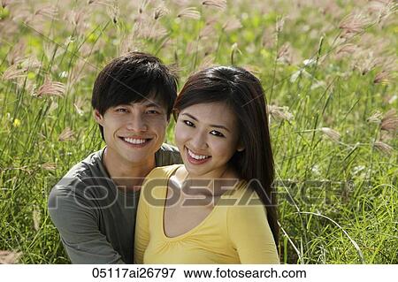 Stock Photo - smiling couple outside in grassy field. Fotosearch