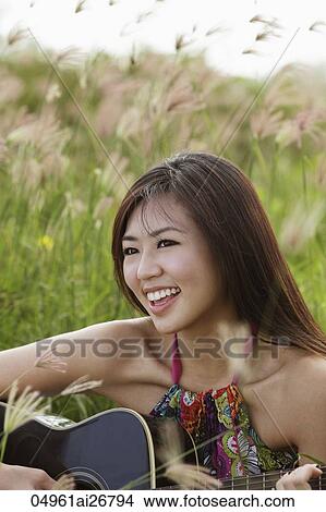 smiling woman playing guitar outside View Large Photo Image Picture - smiling woman playing guitar outside. Fotosearch
