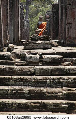Stone carving of Buddha wrapped in orange robe. Angkor Wat, Cambodia View Large Photo Image Stock Photography - Stone carving of Buddha wrapped in orange robe. Angkor Wat, Cambodia. Fotosearch