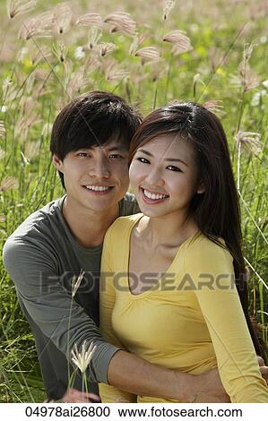 Young couple holding each other in a field View Large Photo Image Stock Image - Young couple holding each other in a field. Fotosearch