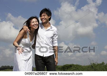 young couple laughing outside with arms around each other View Large Photo Image Stock Photo - young couple laughing outside with arms around each other. Fotosearch