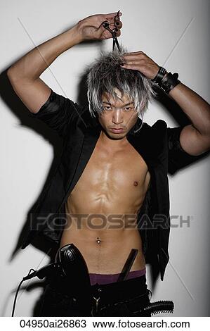 Stock Image - young man cutting his hair with scissors. Fotosearch