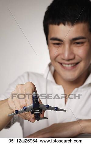 young man holding toy airplane View Large Photo Image Picture - young man holding toy airplane. Fotosearch