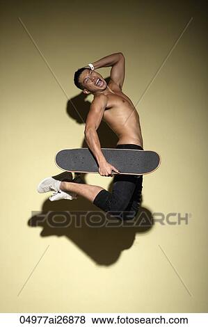 young man jumping while holding a skateboard View Large Photo Image Stock Photo - young man jumping while holding a skateboard. Fotosearch