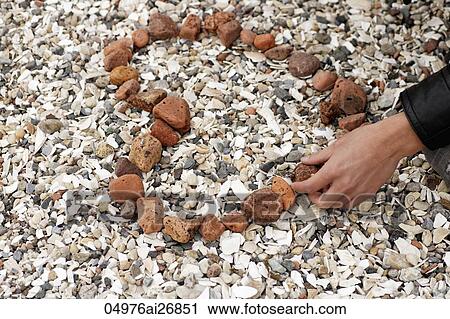 young man making a heart out of stones View Large Photo Image Stock Image - young man making a heart out of stones. Fotosearch