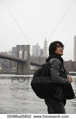 young man wearing a back pack while traveling in the city View Large Photo Image Stock Image - young man wearing a back pack while traveling in the city. Fotosearch