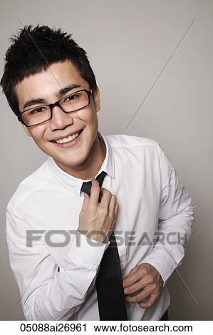 young man wearing glasses and fixing tie View Large Photo Image Stock Image - young man wearing glasses and fixing tie. Fotosearch