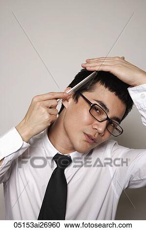 young man wearing glasses combing hair View Large Photo Image Stock Image - young man wearing glasses combing hair. Fotosearch