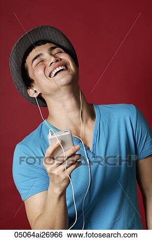 young man with earphones listening to music and laughing View Large Photo Image Stock Photograph - young man with earphones listening to music and laughing. Fotosearch