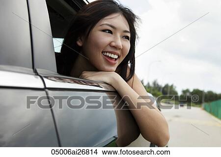 Young woman with head out the car window laughing View Large Photo Image Picture - Young woman with head out the car window laughing. Fotosearch