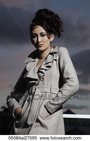 Asian woman wearing coat outside, dark clouds in background View Large Photo Image Stock Photography - Asian woman wearing coat outside, dark clouds in background. Fotosearch