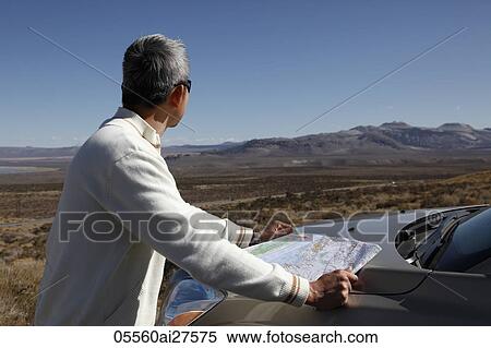 Back view of man looking at a map by his car. View Large Photo Image Stock Photography - Back view of man looking at a map by his car.. Fotosearch