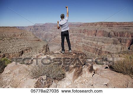 back view of man looking at Grand Canyon with arm outstretched View Large Photo Image Stock Photography - back view of man looking at Grand Canyon with arm outstretched. Fotosearch