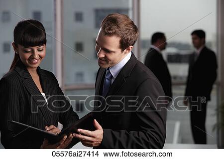 Caucasian man discussing business with colleagues in background View Large Photo Image Picture - Caucasian man discussing business with colleagues in background. Fotosearch