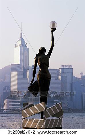 China, Hong Kong, Kowloon, Tsim Sha Tsui, Avenue of the Stars, Bronze Statue with City Skyline in the Background View Large Photo Image Stock Image - China, Hong Kong, Kowloon, Tsim Sha Tsui, Avenue of the Stars, Bronze Statue with City Skyline in the Background. Fotosearch