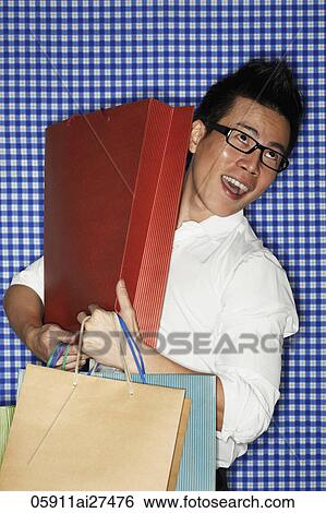 Chinese man holding shopping bags and laughing View Large Photo Image Stock Photograph - Chinese man holding shopping bags and laughing. Fotosearch