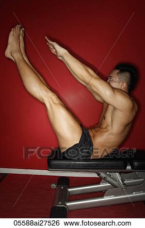 Stock Photograph - Chinese man stretching in gym. Fotosearch