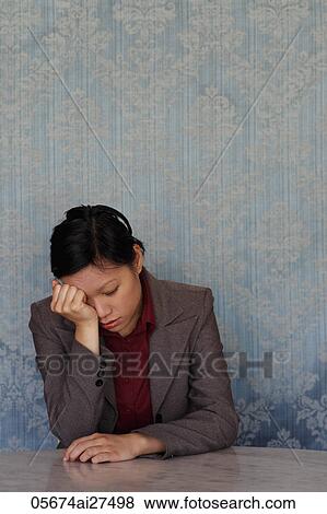 Stock Photo - Chinese woman looking sad with head in her hands. Fotosearch