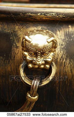 Close up of gold face on giant urn View Large Photo Image Stock Image - Close up of gold face on giant urn. Fotosearch
