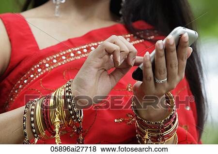 Stock Photo - Close up of Indian woman texting on phone. Fotosearch
