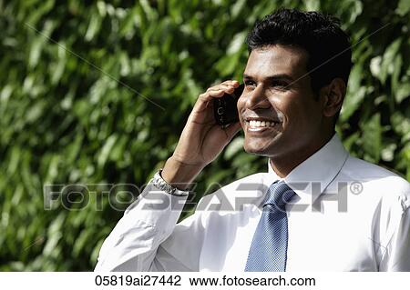 Cropped shot of Indian man talking on phone and smiling View Large Photo Image Stock Image - Cropped shot of Indian man talking on phone and smiling. Fotosearch