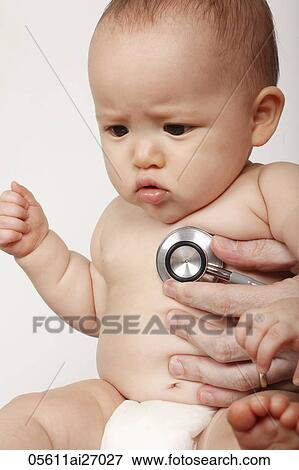 Stock Photo - doctor holding stethoscope to babies chest. Fotosearch