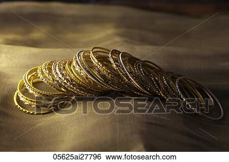 Gold bangles on gold sari View Large Photo Image Stock Photograph - Gold bangles on gold sari. Fotosearch