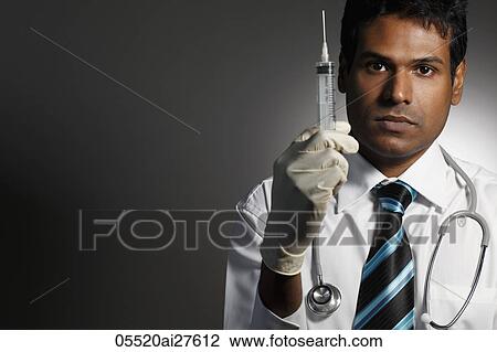 Stock Image - Head shot of doctor holding syringe. Fotosearch