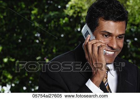 Head shot of Indian man talking on phone outside View Large Photo Image Stock Photography - Head shot of Indian man talking on phone outside. Fotosearch