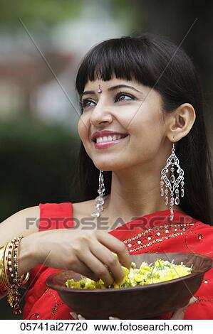 Head shot of Indian woman looking up and holding bowl of flowers View Large Photo Image Stock Image - Head shot of Indian woman looking up and holding bowl of flowers. Fotosearch